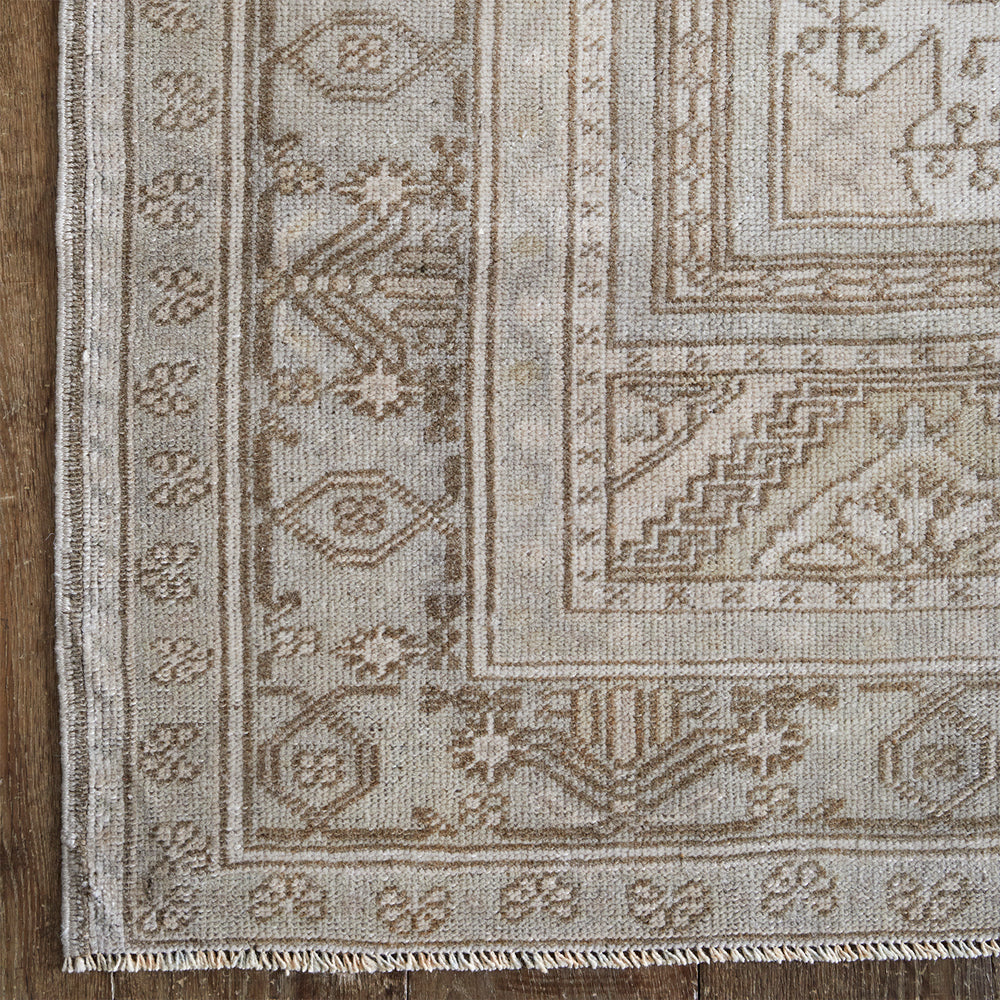 Lemieux et Cie Anatolian Village Rug in neutral tones with geometric pattern, vintage Turkish wool rug detail shown on wood flooring.