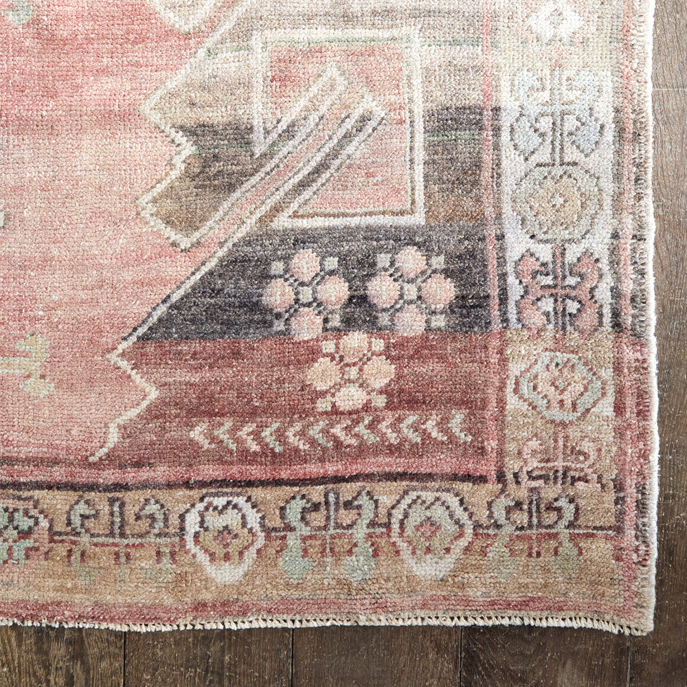 Lemieux et Cie Anatolian Village Rug in rose, charcoal and sage geometric pattern, vintage handwoven wool rug shown on dark wood flooring.