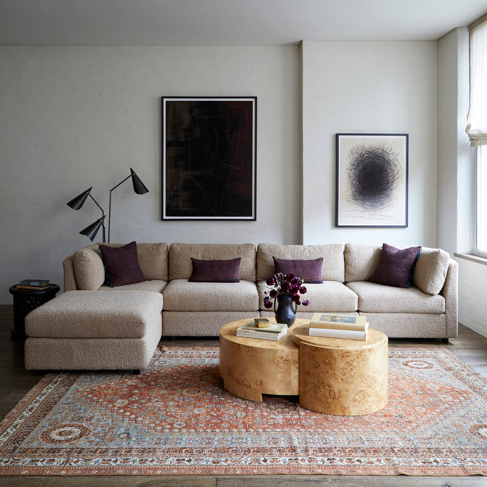 Lemieux et Cie Anatolian Village Rug in warm terracotta and blue geometric pattern, vintage handwoven wool rug layered in a sitting room with wood floors and neutral walls.