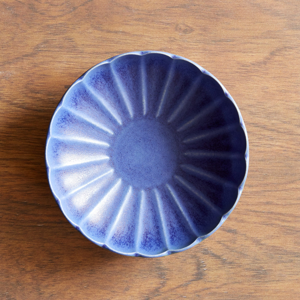 Lemieux et Cie Dhalia Stoneware Pasta Bowl in blue with scalloped edges, ceramic dinnerware shown on warm wood surface.