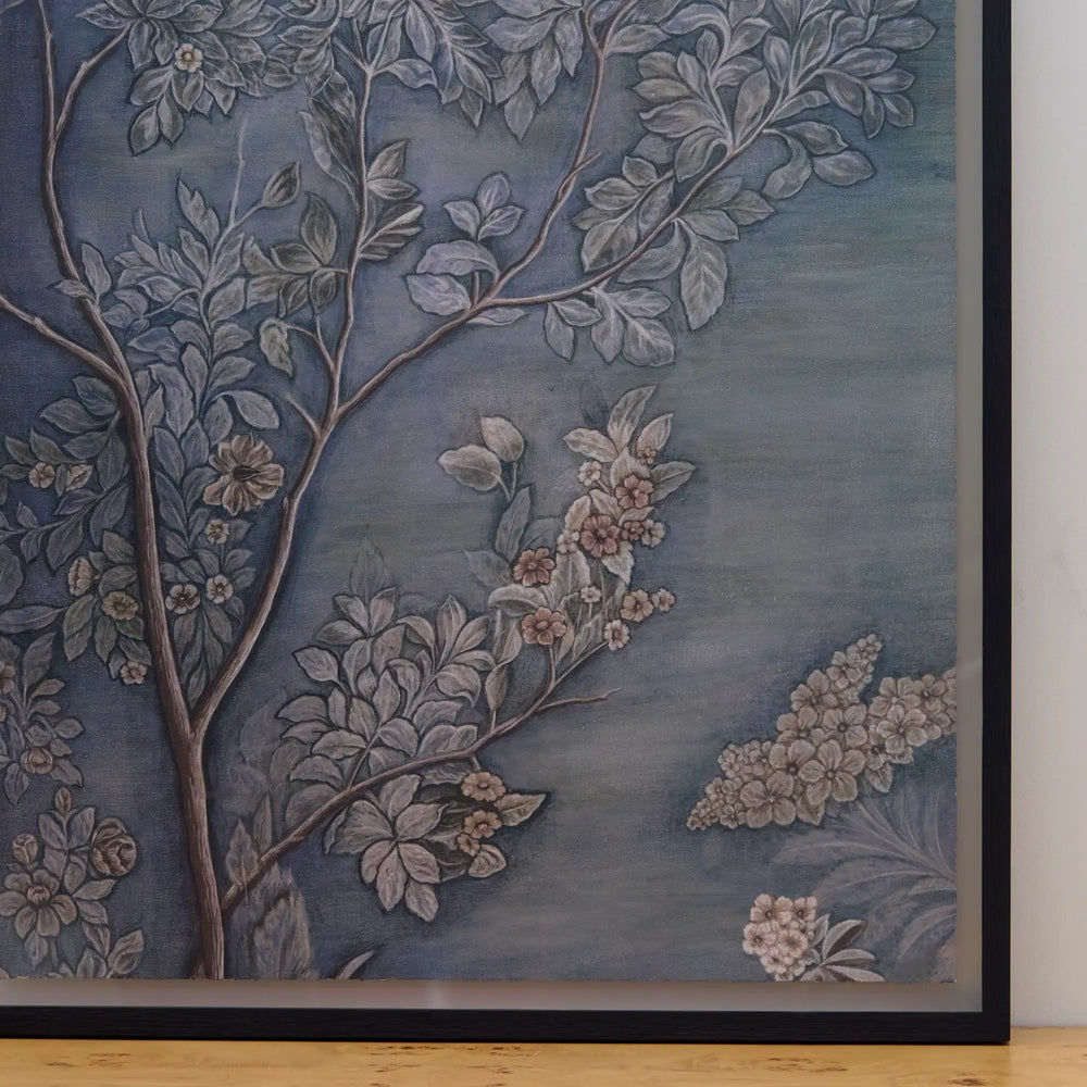Lemieux et Cie Émeraude Un fine art print detail, botanical branches with blossoms in blue-gray and blush tones, framed in matte black against light wood floor.