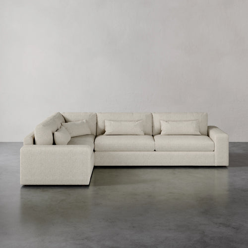Lemieux et Cie Lacroix Right Arm Sectional in warm neutral upholstery, modular sofa with deep cushions and bolster pillows on concrete floor.