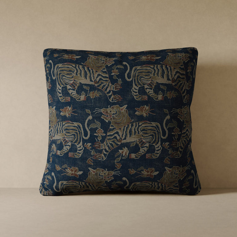 Lemieux et Cie Tiger Velvet Pillow in indigo performance velvet, decorative pillow with Tibetan tiger motif, shown on neutral plaster surface in warm light.
