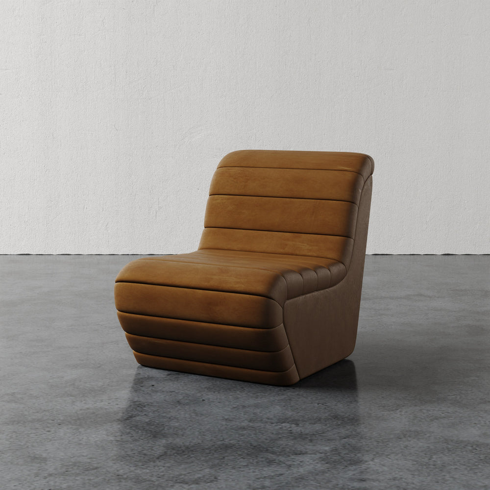 Lemieux et Cie Brunoy Leather Chair in warm tobacco leather with channeled upholstery, sculptural slipper chair on polished concrete floor.