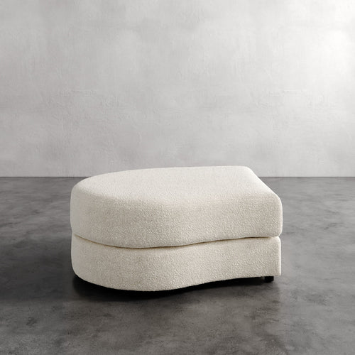 Lemieux Et Cie Rulmann Left Ottoman Beige ottoman on a gray floor with a plain wall background
