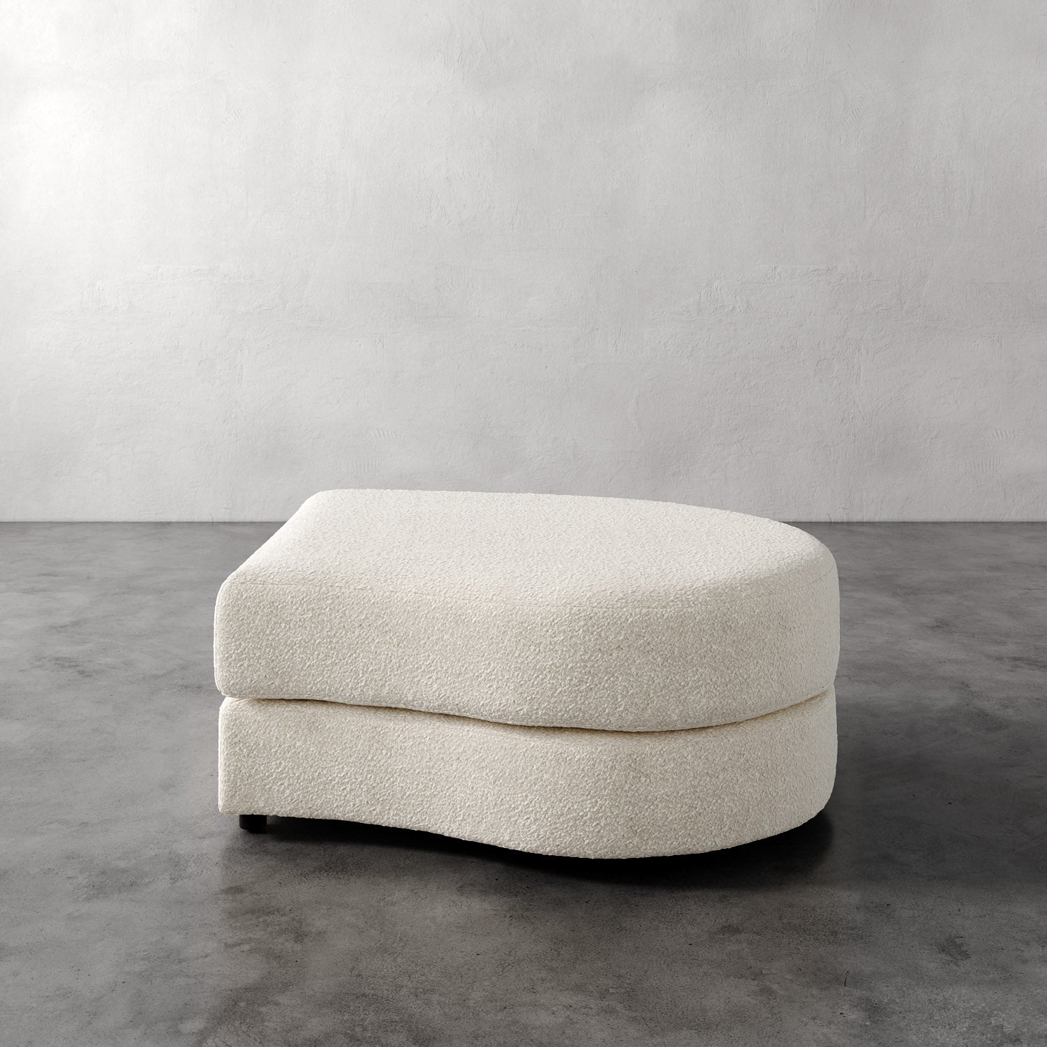 Lemieux Et Cie Rulmann Right Ottoman Beige ottoman on a gray floor with a plain white wall background