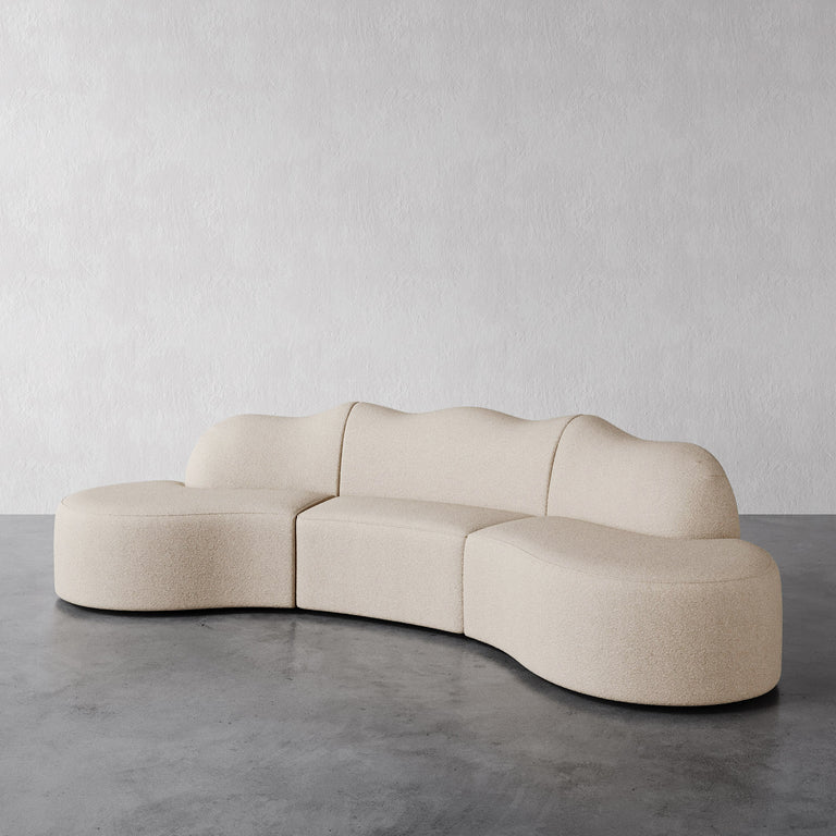 Lemieux Et Cie Serpentine 3-Piece Sectional Beige modular sofa on a gray floor with a plain white wall background