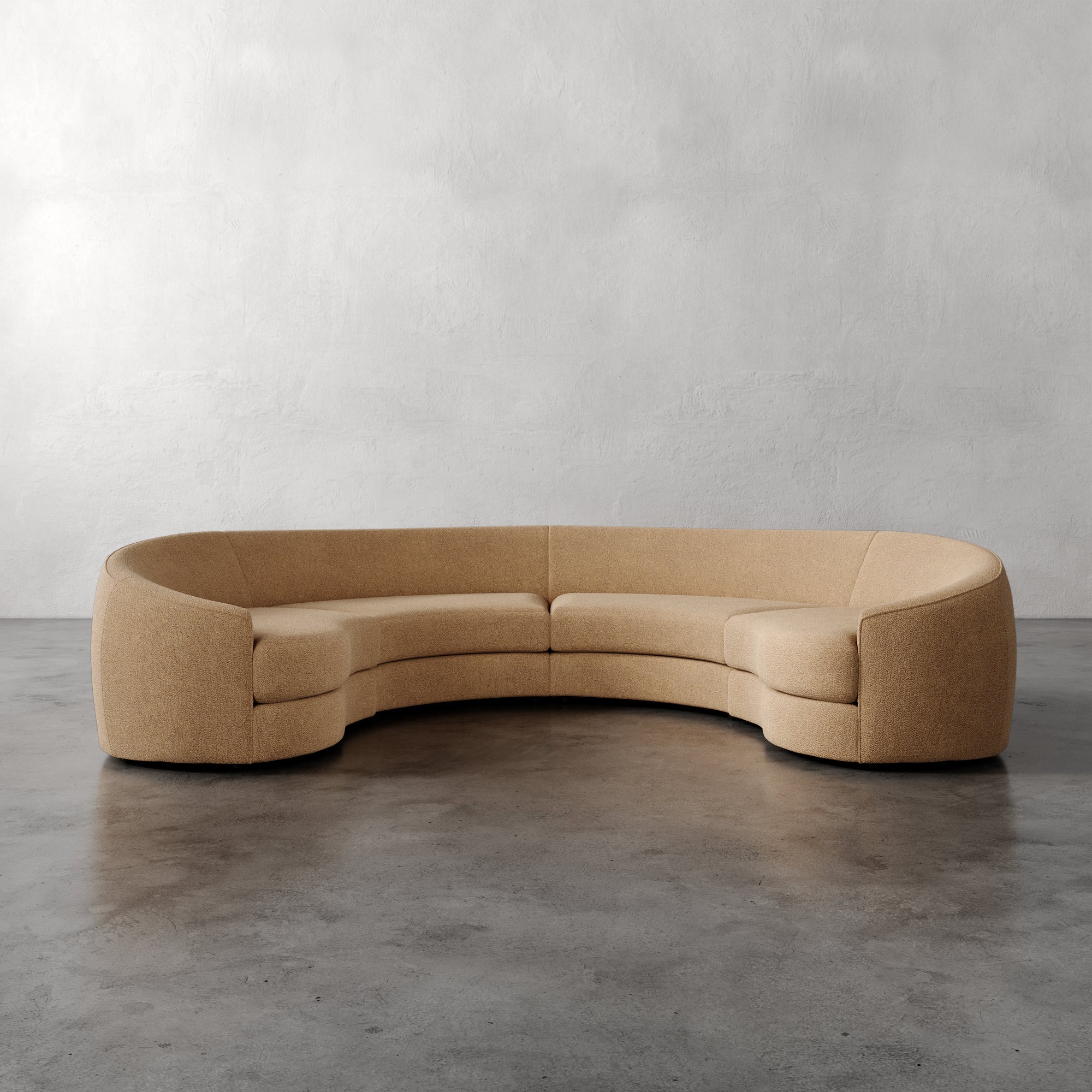 Lemieux Et Cie Rulmann 4-Piece Sectional Beige curved sofa on a gray floor with a plain wall background