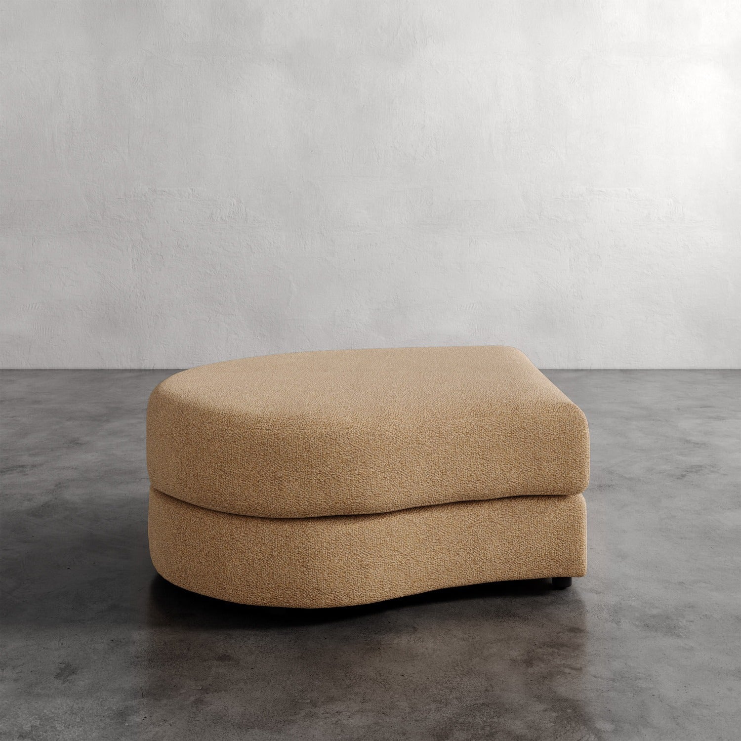 Lemieux Et Cie Rulmann Left Ottoman Beige ottoman on a gray floor with a plain white wall background