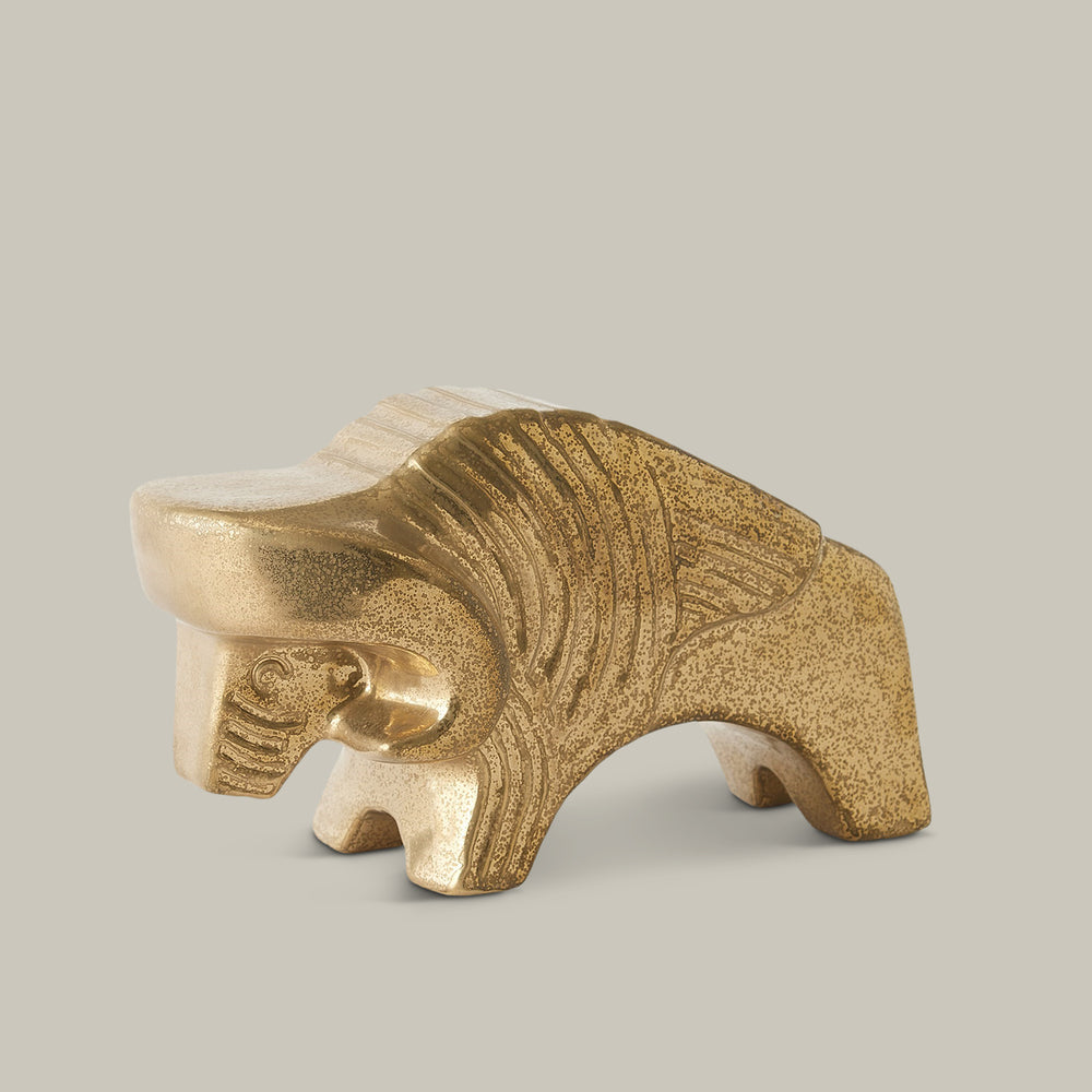Lemieux et Cie sculptural bison figure with textured golden finish and carved ridges, decorative object shown on neutral studio backdrop.