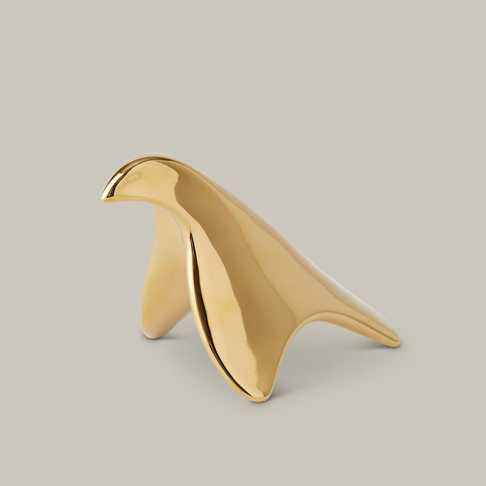 Lemieux et Cie sculptural bird object in polished brass, decorative accent with organic curved form shown on neutral studio backdrop.