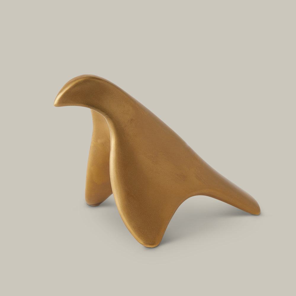 Lemieux et Cie sculptural bird object in warm golden tone, organic curved form shown on neutral studio backdrop.
