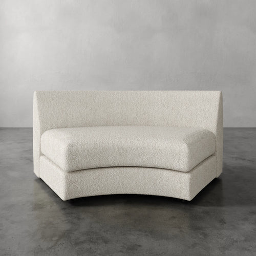 Lemieux Et Cie Rulmann Wedge Curved beige sofa against a gray background