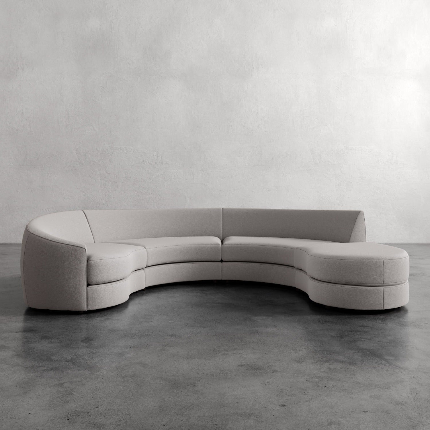 Lemieux Et Cie Rulmann 4-Piece Left Sectional Modern curved sofa in a minimalistic setting with a plain wall and concrete floor.