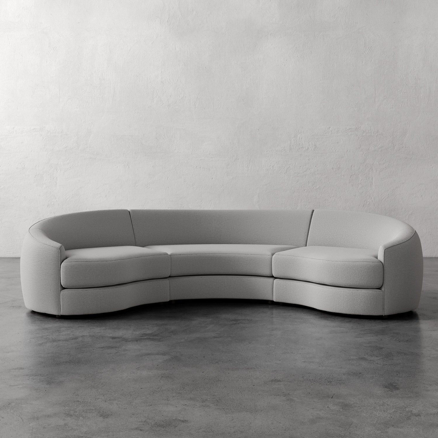 Lemieux Et Cie Rulmann Rulmann 3-Piece Sectional Gray curved sectional sofa on a concrete floor with a white wall background