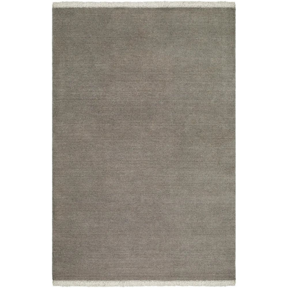 Lemieux et Cie Plume Handmade Wool Rug in grey, solid textured rug with fringe detail, shown on white studio backdrop.
