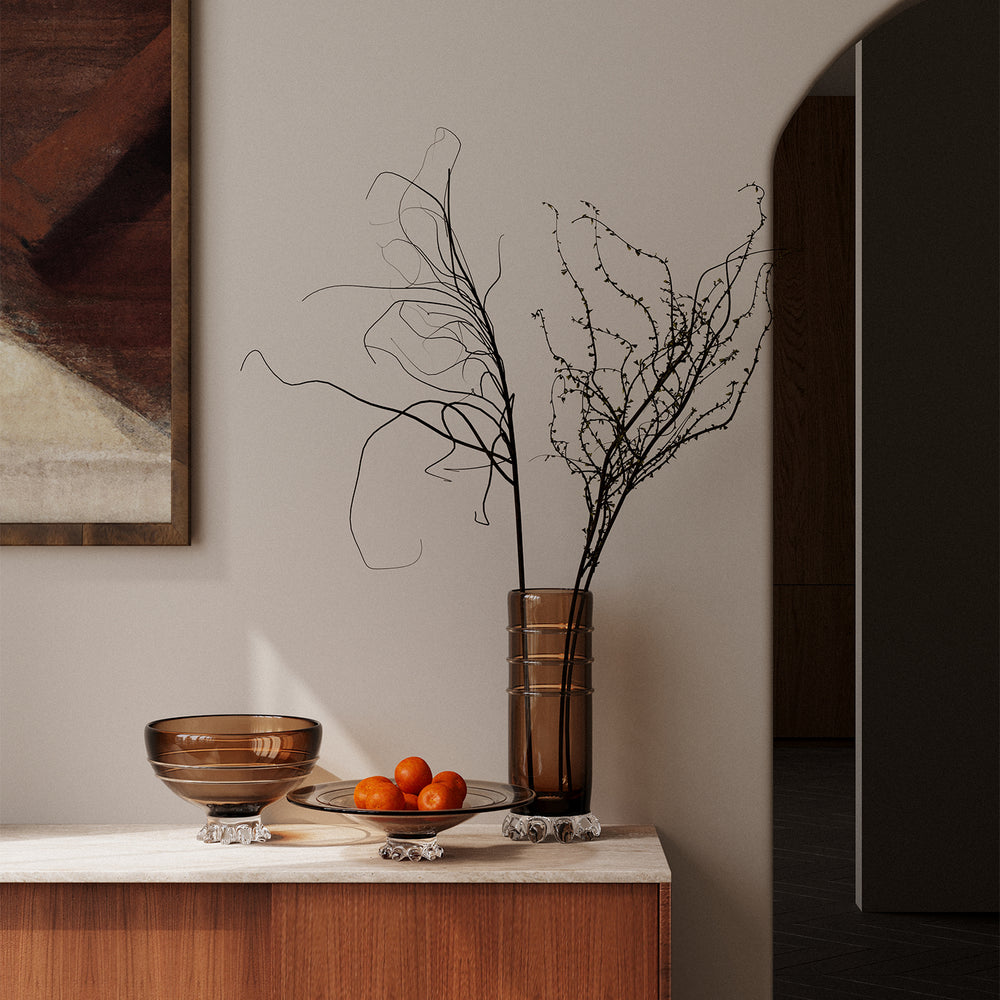 Lemieux et Cie pink blush marble pedestal table, cylindrical form on stone top, styled with warm-toned vessels and fruit on neutral sideboard.