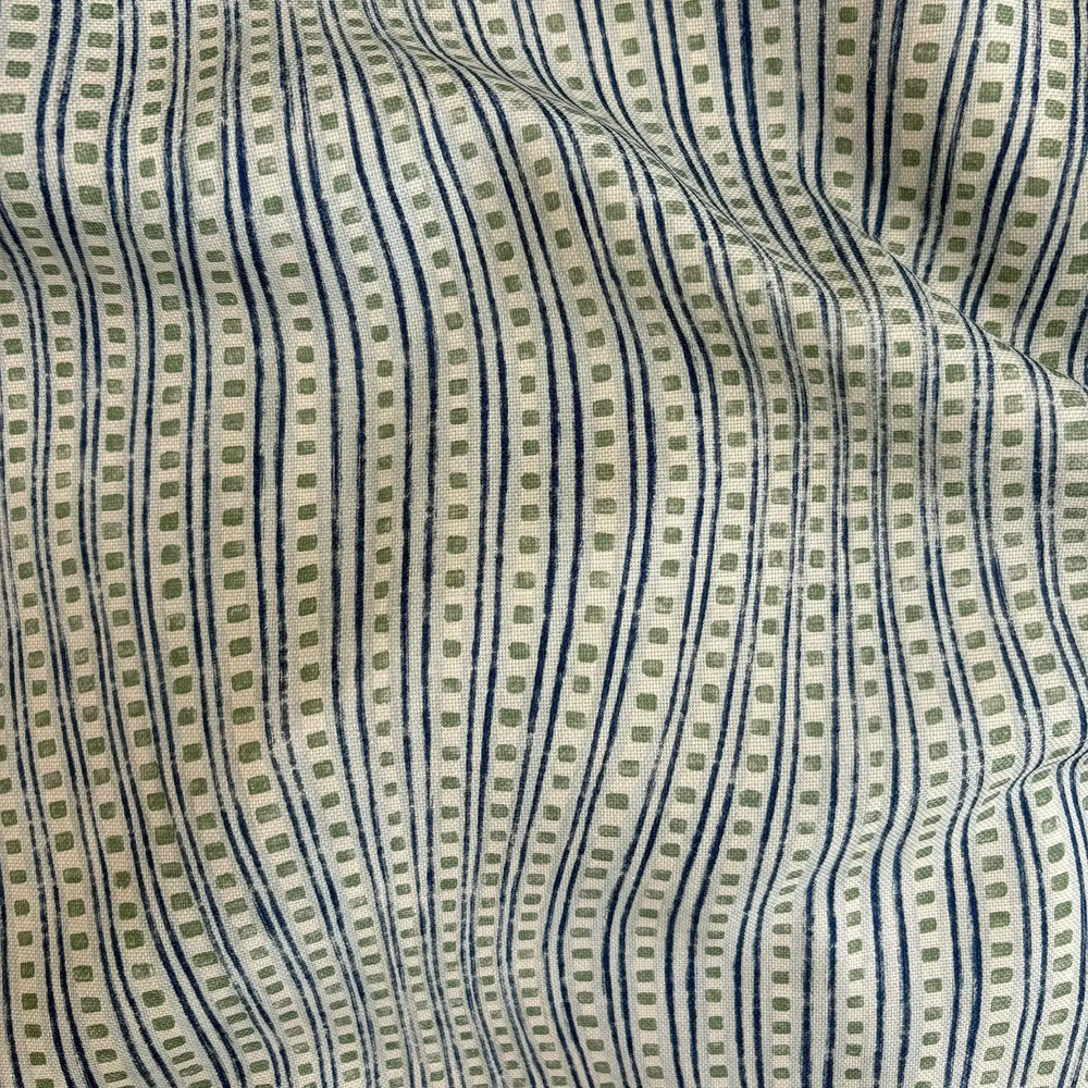 Lemieux et Cie Outdoor Pillow in green, ivory and blue striped pattern, textile close-up showing soft folds and woven texture.