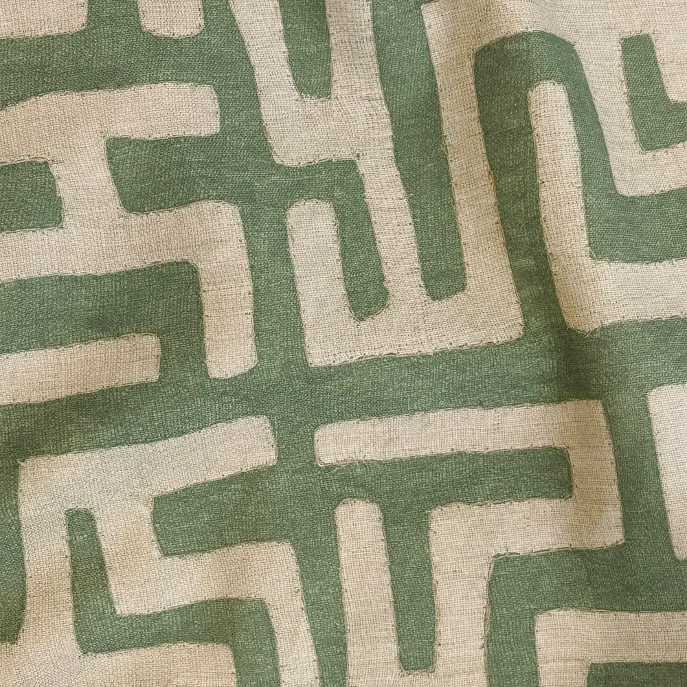 Lemieux et Cie Outdoor Pillow in Kuba Cloth Green, geometric pattern in sage and ivory on textured surface, close-up detail shot.