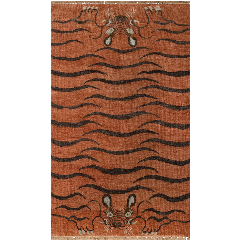 Lemieux et Cie Kouang rug in rust orange with dark tiger stripe pattern, hand-knotted wool rug with low pile shown on white studio backdrop.