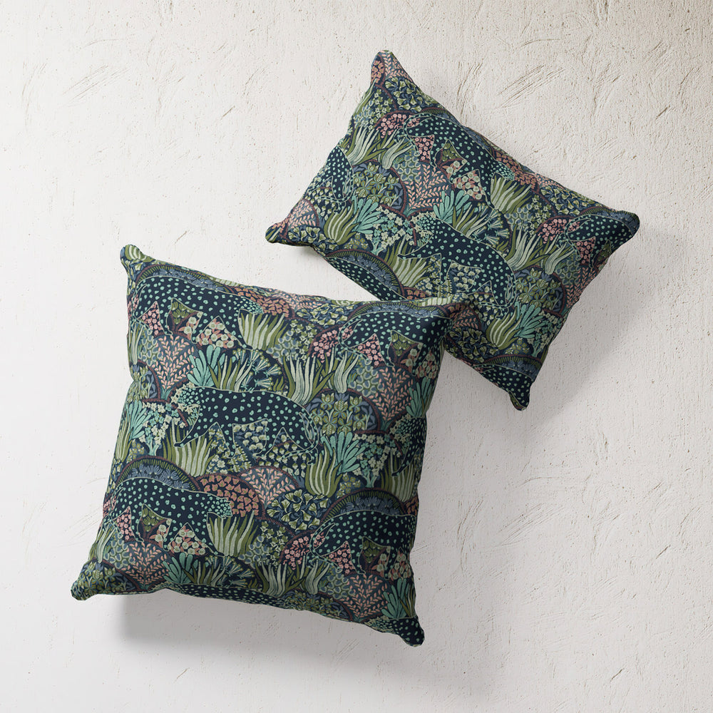 Lemieux et Cie Outdoor Pillow in Leopard Floral print, decorative pillows with dark botanical pattern, shown on textured plaster wall.