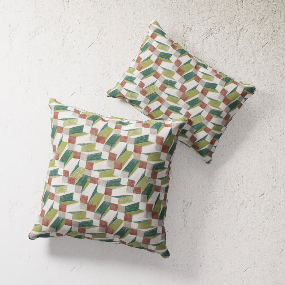 Lemieux et Cie Outdoor Pillow in Op Art Green geometric pattern, two throw pillows with green, coral and ivory motif on textured plaster backdrop.