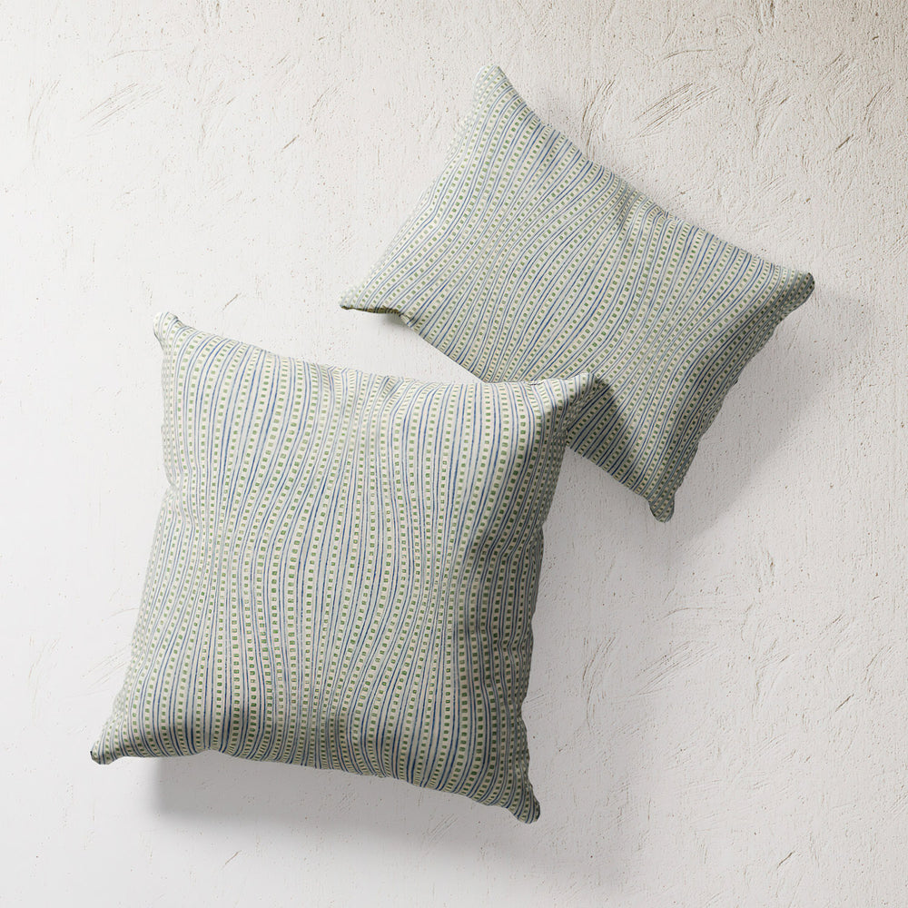 Lemieux et Cie Outdoor Pillow in Wavy Stripe Green, double-sided pillows with fine striped pattern, shown against textured plaster wall