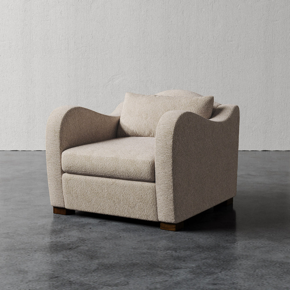 Lemieux et Cie Elodie Chair in textured bouclé upholstery, low-profile lounge chair on polished concrete floor against neutral plaster wall.