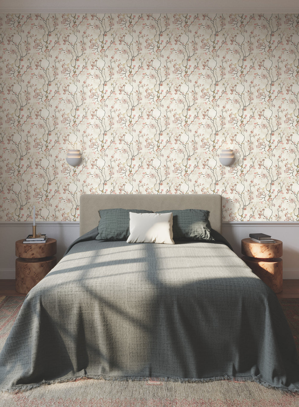 Lemieux et Cie Avril Chinoiserie wallpaper in pink rose on watercolor tan, flowering branch pattern covering bedroom walls with paired sconces and burl nightstands.
