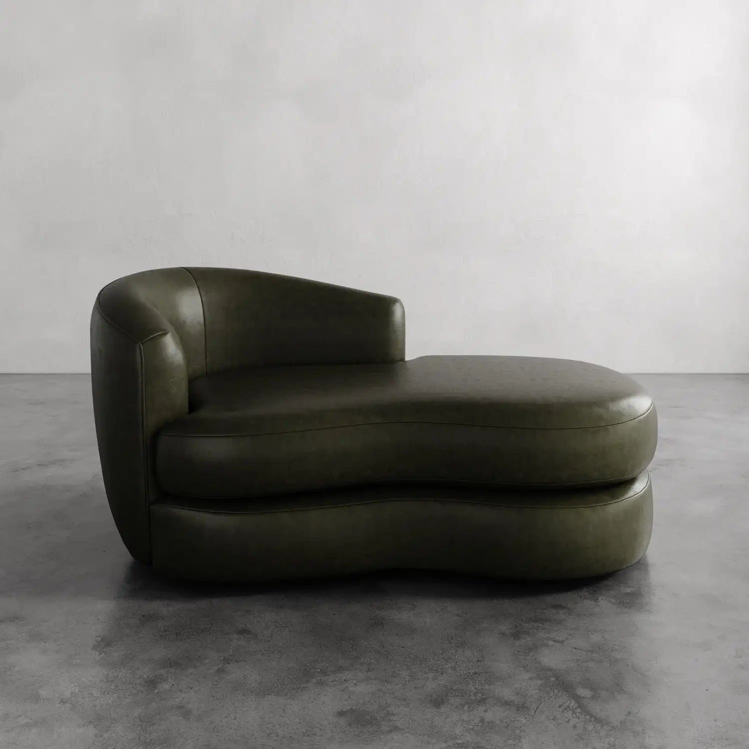 Lemieux et Cie Rulmann Leather Left Arm Chaise in olive green leather, sculptural low-slung chaise shown on concrete floor against neutral wall.