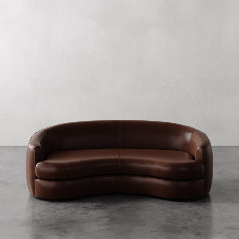 Lemieux et Cie Dark Brown Rulmann leather sofa on a gray floor with a white wall background