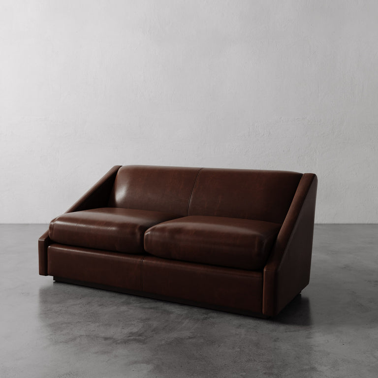 Lemieux Et Cie dark brown Fontaine Leather Sofa on a gray floor with a white wall background.