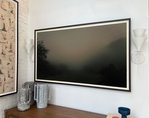 Lemieux et Cie Nara Limited Edition Art Photograph, framed landscape with dark horizon, hung above wood console with ceramic vessels and white brick walls.