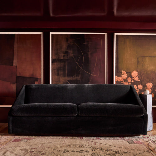 Lemieux et Cie Black Fontaine sofa in a room with abstract art on the wall.
