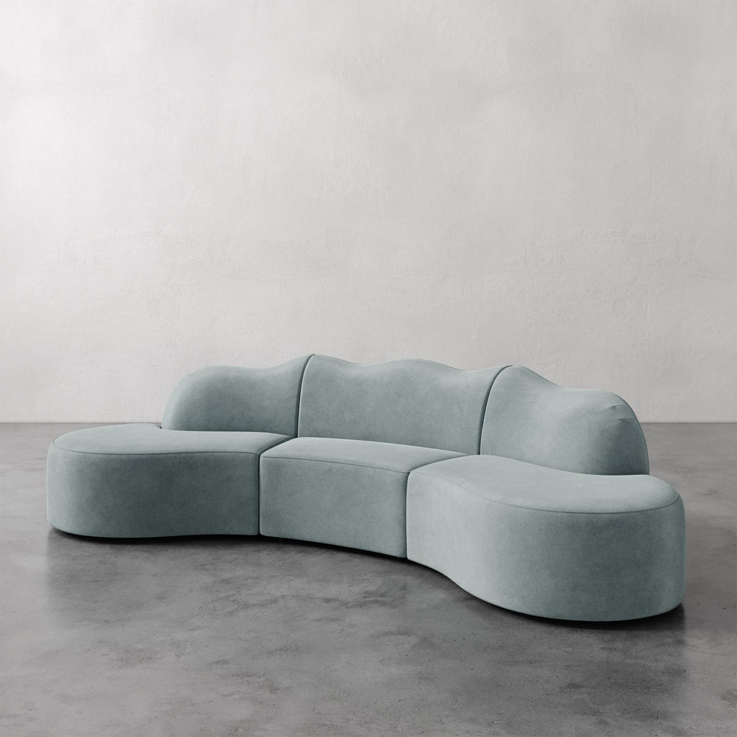 Lemieux et Cie Serpentine Sectional Sofa in sage upholstery, modular curved form on polished concrete floor against white plaster wall