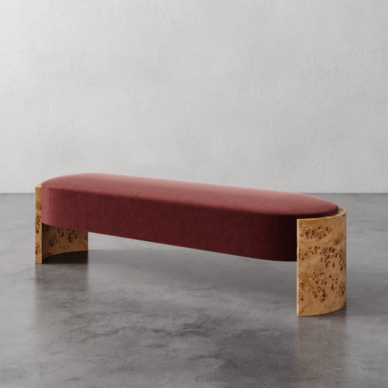 Lemieux et Cie Benoit Custom Upholstered Bench in warm rose velvet with curved Maple burl legs, shown on polished concrete floor against white walls.