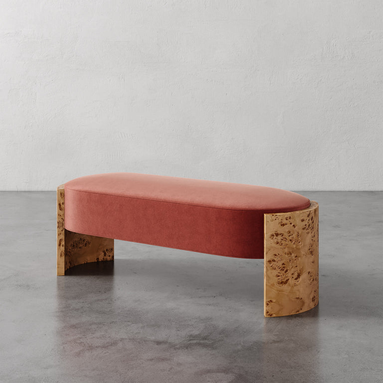 Lemieux et Cie Benoit Custom Upholstered Bench in terracotta velvet with curved Maple burl legs, shown on polished concrete floor against textured plaster wall.