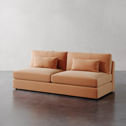 Lemieux Et Cie Lacroix Armless Sofa Orange sofa with cushions on a gray floor and white wall