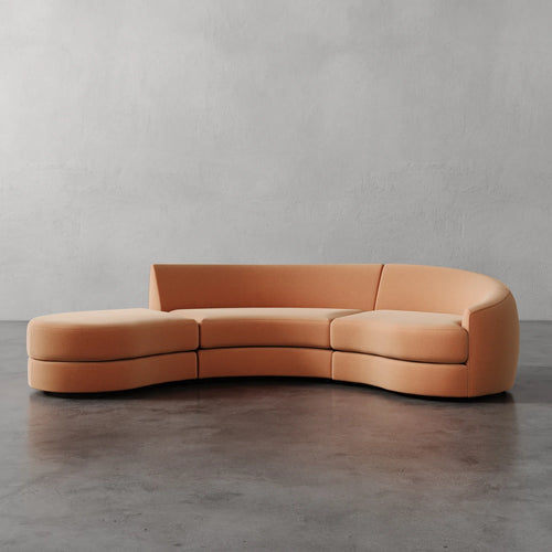Lemieux et Cie Rulmann 3-Piece Right Sectional in warm tan, curved modular sofa with sculptural rounded forms, shown on concrete floor against textured plaster walls.