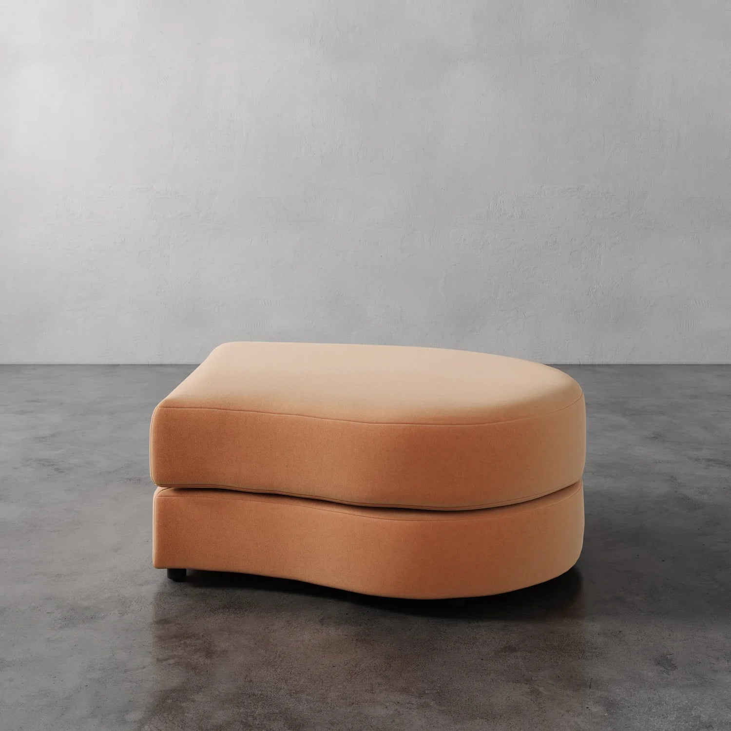 Lemieux Et Cie Rulmann Right Ottoman Orange ottoman on a gray floor with a plain gray wall background