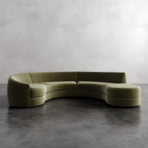 Lemieux Et Cie Rulmann 4-Piece Left Sectional Curved green sofa on a gray floor with a plain wall background
