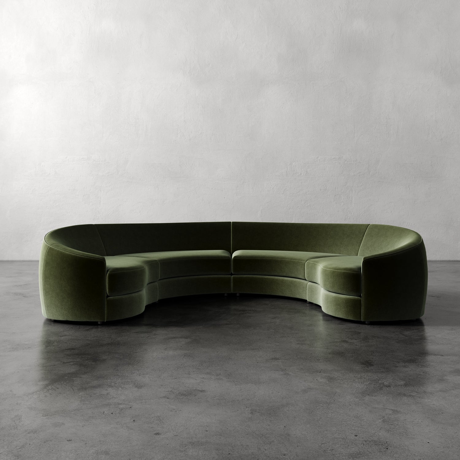 Lemieux Et Cie Rulmann 4-Piece Sectional Green curved sofa on a gray floor with a plain gray wall background