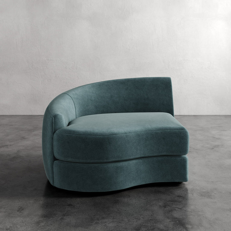 Lemieux Et Cie Rulmann Left Arm Chair Teal curved sofa against a plain wall