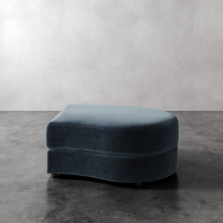 Lemieux Et Cie Rulmann Right Ottoman Blue ottoman on a gray floor with a white wall background