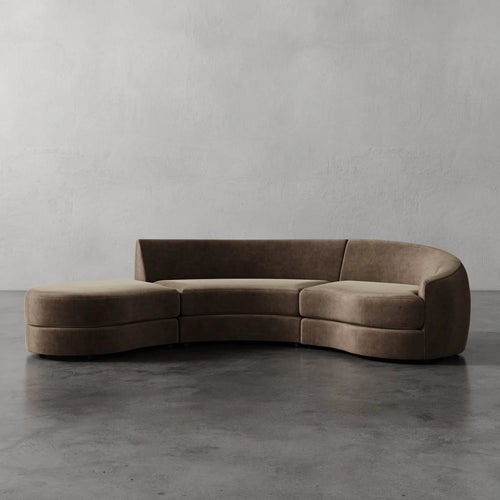 Lemieux Et Cie Rulmann 3-Piece Right Sectional Brown curved sofa on a gray floor with a plain gray wall background