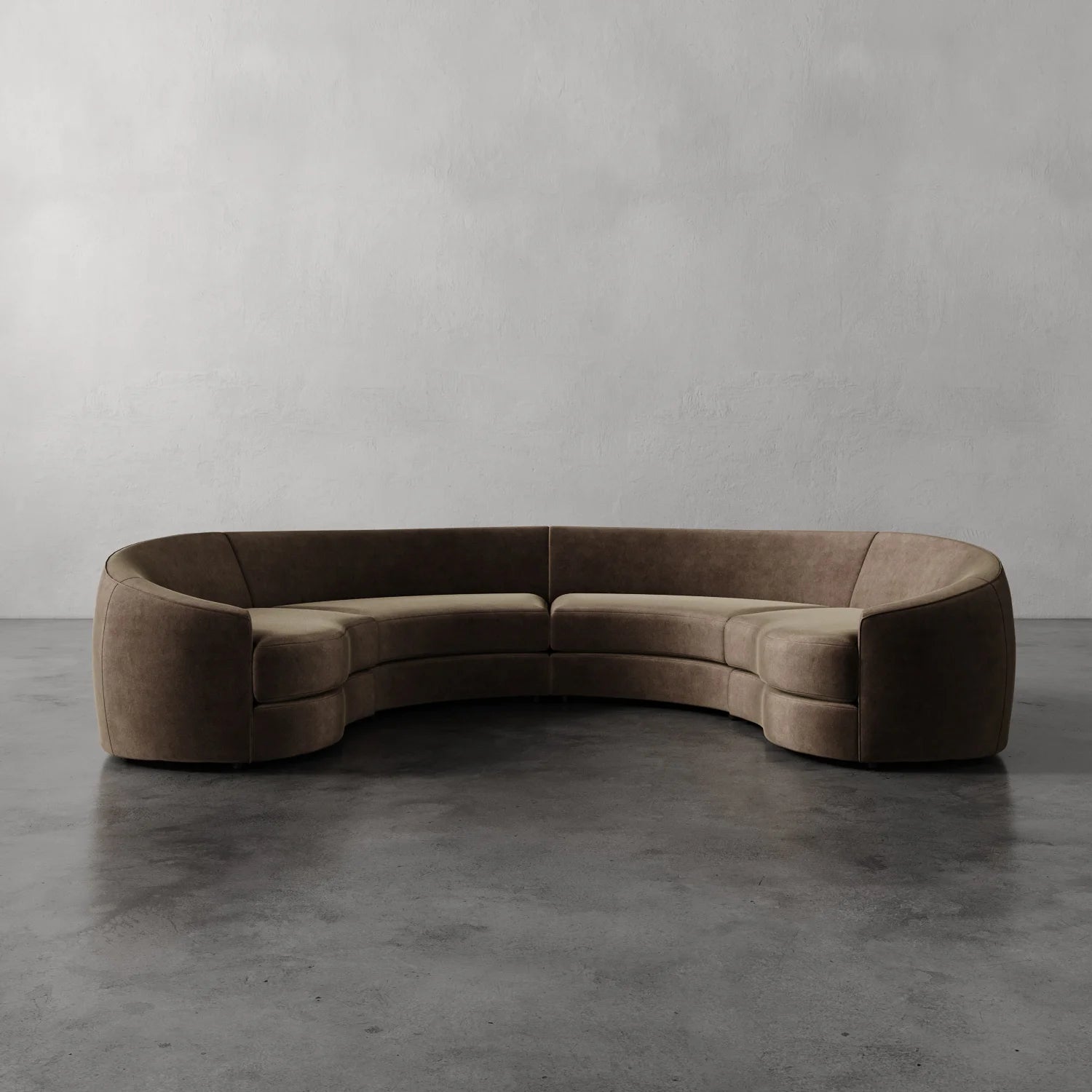 Lemieux Et Cie Rulmann 4-Piece Sectional Brown curved sofa on a gray floor with a plain gray wall background