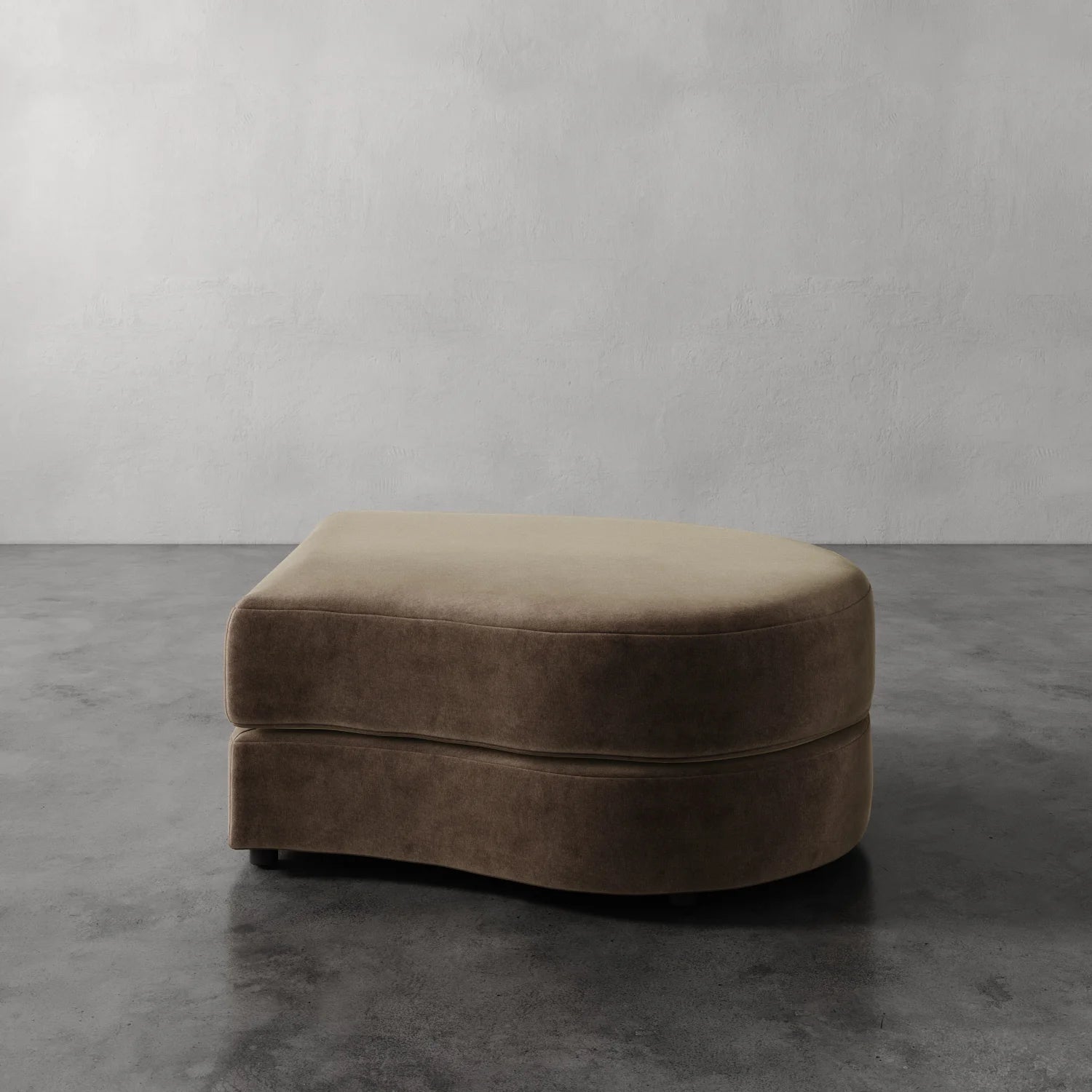 Lemieux Et Cie Rulmann Right Ottoman Brown ottoman on a gray floor with a plain wall background