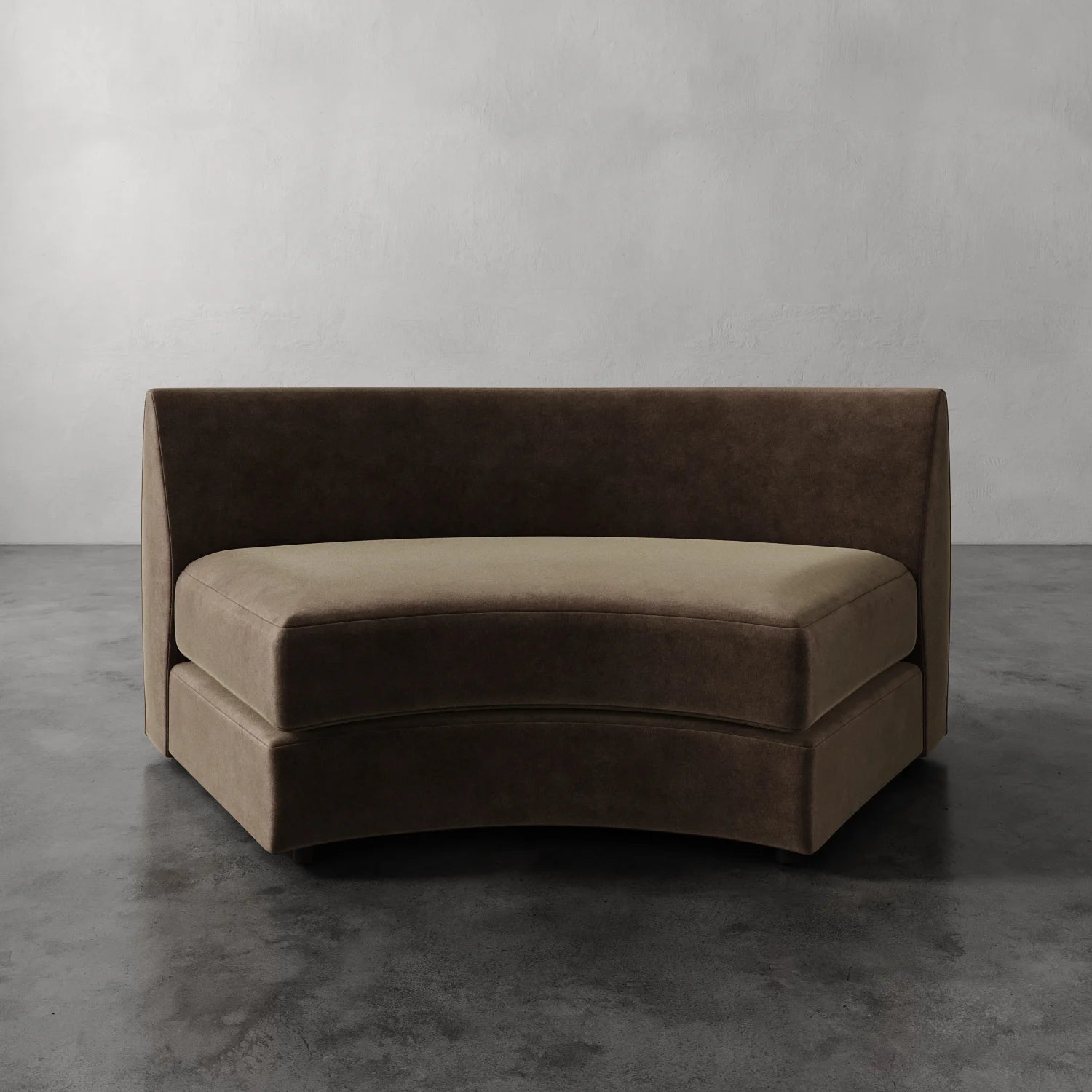 Lemieux Et Cie Rulmann Wedge Brown curved sofa against a gray wall