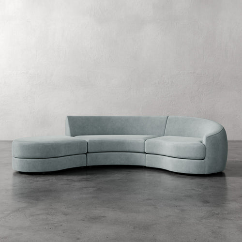 Lemieux Et Cie Rulmann 3-Piece Right Sectional Modern curved sofa in a minimalistic setting with a plain wall and concrete floor.