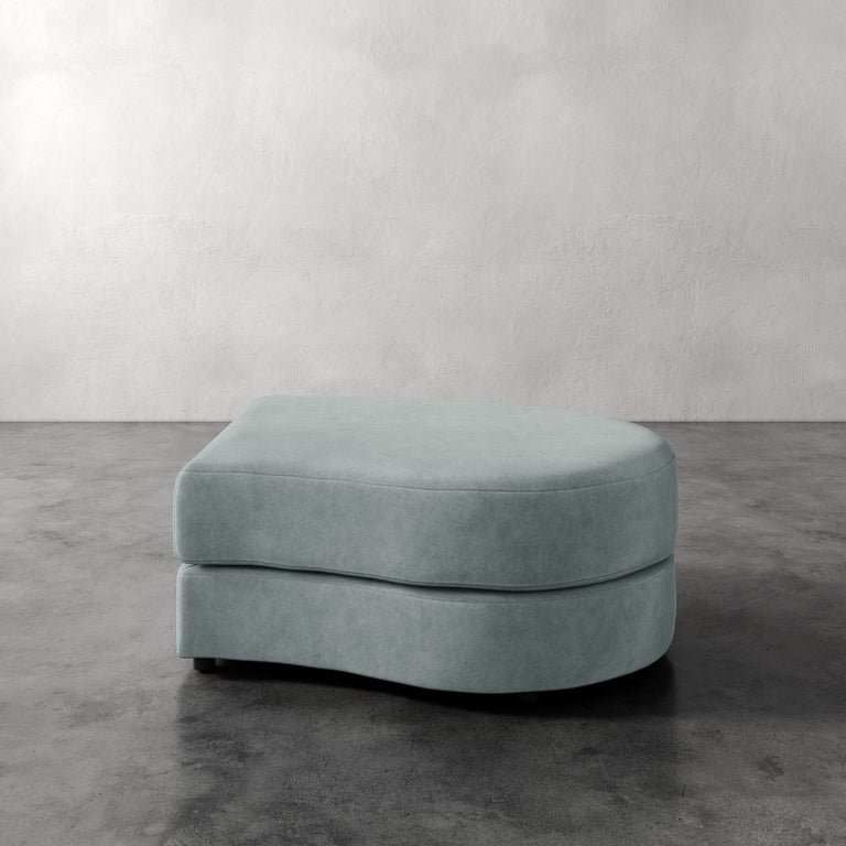 Lemieux Et Cie Rulmann Right Ottoman Light blue ottoman on a gray floor with a white wall background